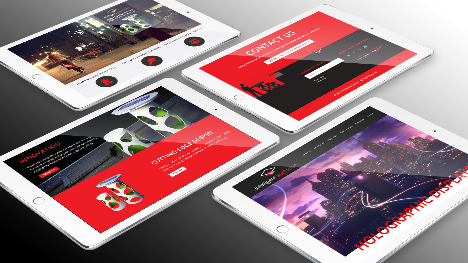 This depiction by PixelUp showcases four iPads positioned against a backdrop of a dark grey gradient. Each iPad screen features a webpage showcasing captivating elements from Intelligent Surfaces's website, with vibrant red hues prominently featured in the design. This forms a component of PixelUp's Intelligent Surfaces Project.