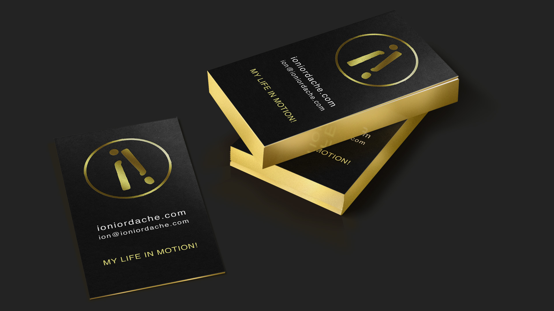 This picture, created by PixelUp, showcases Ion Iordache's business card design adorned with golden tones, set against a dark grey background. Three sets of business cards are arranged, with two stacked atop each other and one placed beside them. The cards are black with gold edges and intricately engraved in gold. Ion Iordache's brand identity is among PixelUp's endeavours.